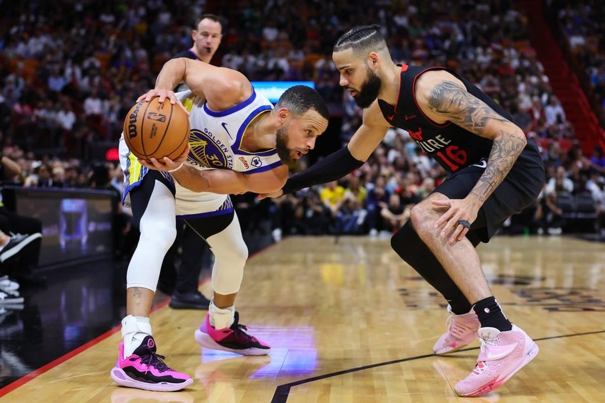 Mar 26, 2024; Miami, Florida, USA; Golden State Warriors guard Stephen Curry (30) protects the basketball from Miami Heat forward Caleb Martin (16) during the first quarter at Kaseya Center.