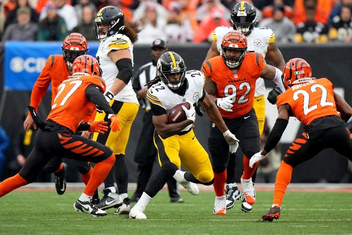 Pittsburgh Steelers running back Najee Harris (22) carries the ball as Cincinnati Bengals safety Jordan Battle (27) and Cincinnati Bengals cornerback Chidobe Awuzie (22) defend in the first quarter of a Week 12 NFL football game between the Pittsburgh Steelers and the Cincinnati Bengals, Sunday, Nov. 26, 2023, at Paycor Stadium.