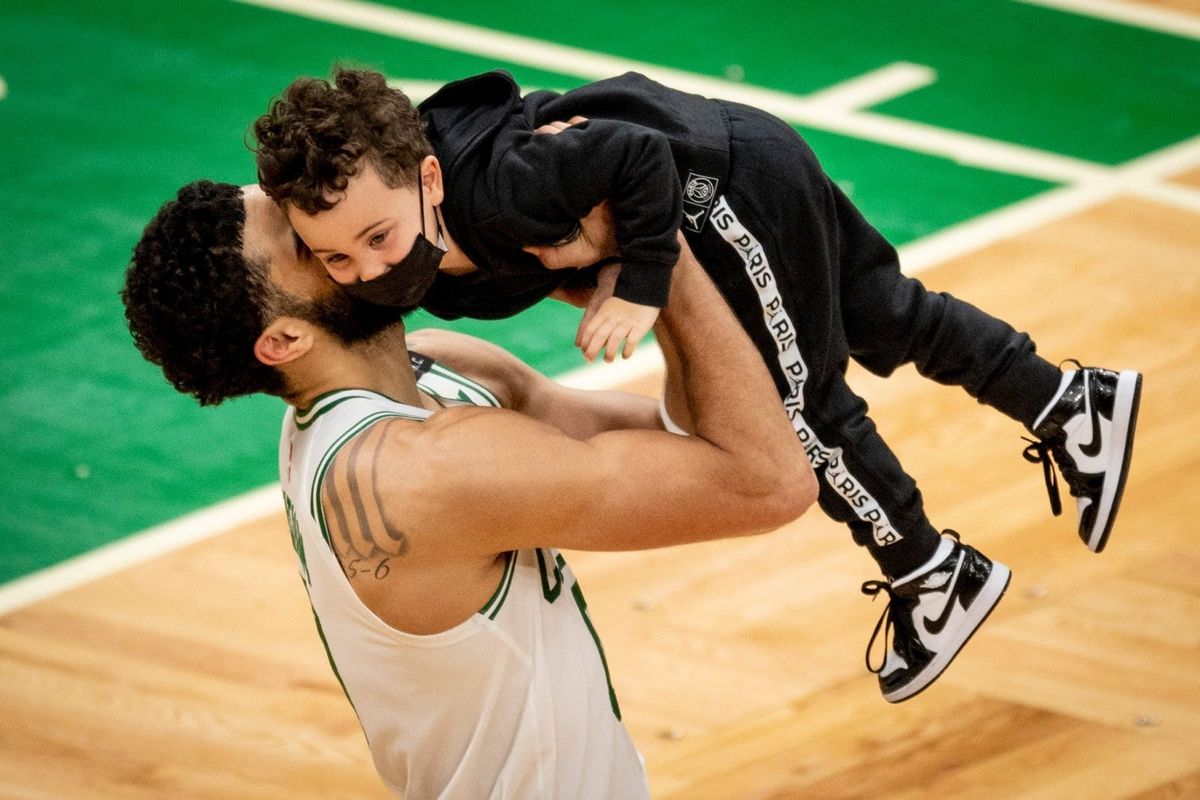 Jayson Tatum lifts his son, Deuce, after the game.