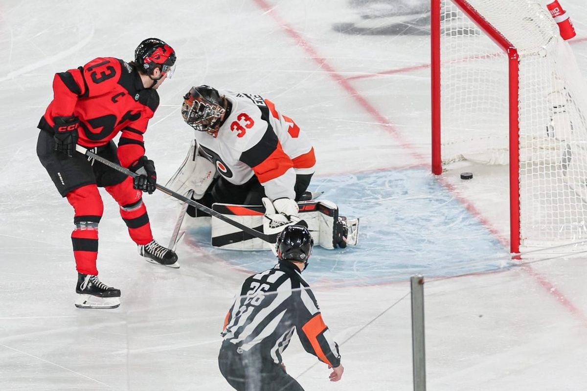 Feb 17, 2024; East Rutherford, New Jersey, USA; New Jersey Devils center Nico Hischier (13) scores a goal past Philadelphia Flyers goaltender Samuel Ersson (33) during the first period in a Stadium Series ice hockey game at MetLife Stadium.