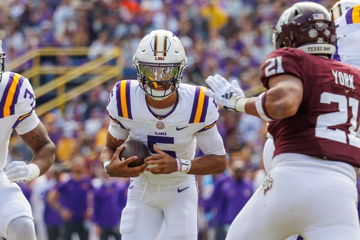 Nov 25, 2023; Baton Rouge, Louisiana, USA;  LSU Tigers quarterback Jayden Daniels (5) rushes against Texas A&M Aggies linebacker Taurean York (21) during the first half at Tiger Stadium.