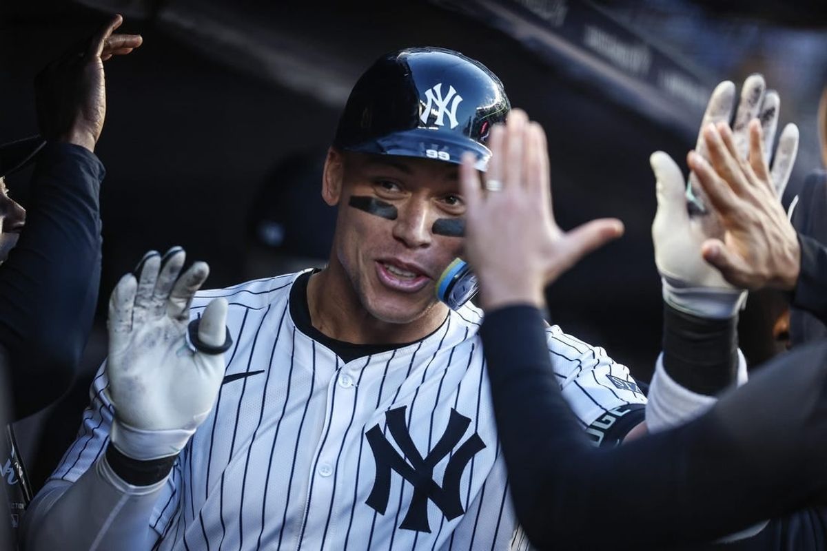 Apr 24, 2024; Bronx, New York, USA; New York Yankees center fielder Aaron Judge (99) celebrates with teammates in the dugout  after hitting a two run home run in the first inning against the Oakland Athletics at Yankee Stadium.