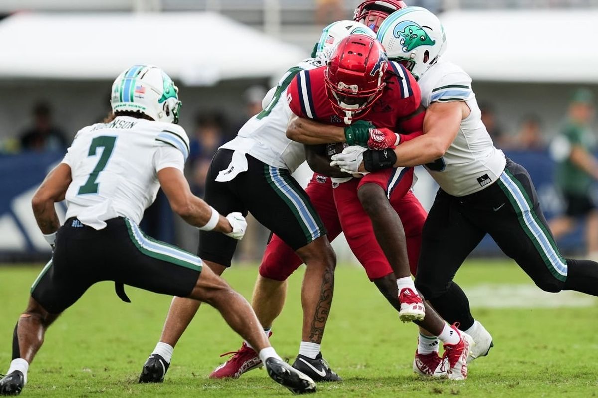 Nov 18, 2023; Boca Raton, Florida, USA; Florida Atlantic Owls wide receiver Tony Johnson (0) is tackled while running the ball against the Tulane Green Wave the first half at FAU Stadium.