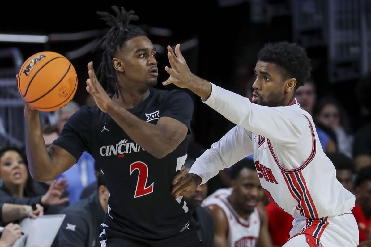 Feb 10, 2024; Cincinnati, Ohio, USA; Cincinnati Bearcats guard Jizzle James (2) holds the ball against Houston Cougars guard Mylik Wilson (8) in the first half at Fifth Third Arena.