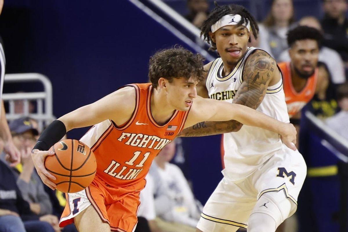 Jan 18, 2024; Ann Arbor, Michigan, USA;  Illinois Fighting Illini guard Niccolo Moretti (11) dribbles the ball while Michigan Wolverines guard Dug McDaniel (0) defends in the first half at Crisler Center.
