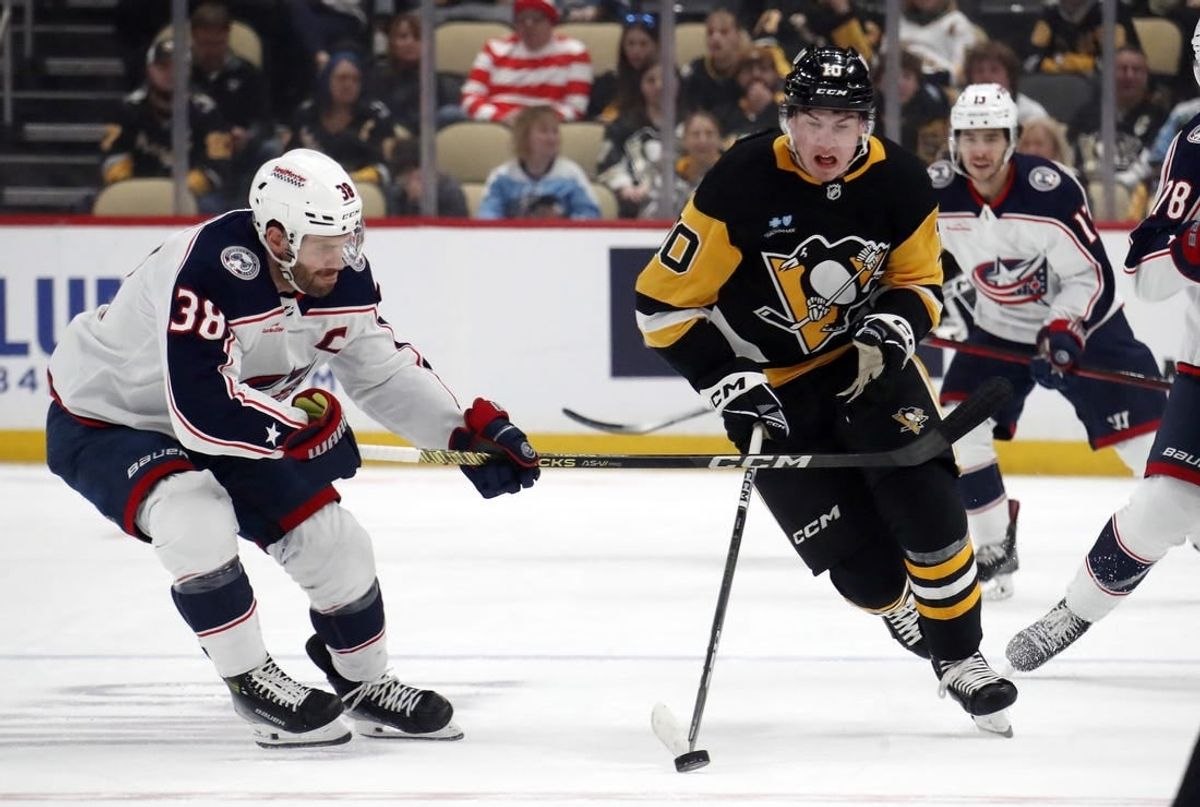 Mar 5, 2024; Pittsburgh, Pennsylvania, USA; Pittsburgh Penguins left wing Drew O'Connor (10) moves the puck up ice against Columbus Blue Jackets center Boone Jenner (38) during the first period at PPG Paints Arena.
