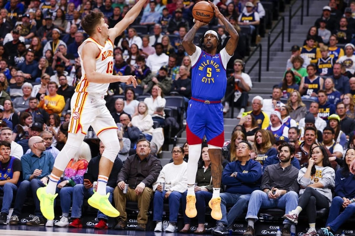 Apr 6, 2024; Denver, Colorado, USA; Denver Nuggets guard Kentavious Caldwell-Pope (5) shoots a three-point shot over Atlanta Hawks guard Bogdan Bogdanovic (13) in the first half at Ball Arena.