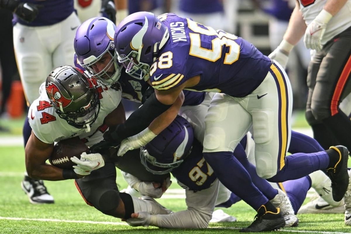 Sep 10, 2023; Minneapolis, Minnesota, USA; Tampa Bay Buccaneers running back Sean Tucker (44) runs the ball as Minnesota Vikings linebacker Jordan Hicks (58) and defensive tackle Harrison Phillips (97) make the tackle during the game at U.S. Bank Stadium.
