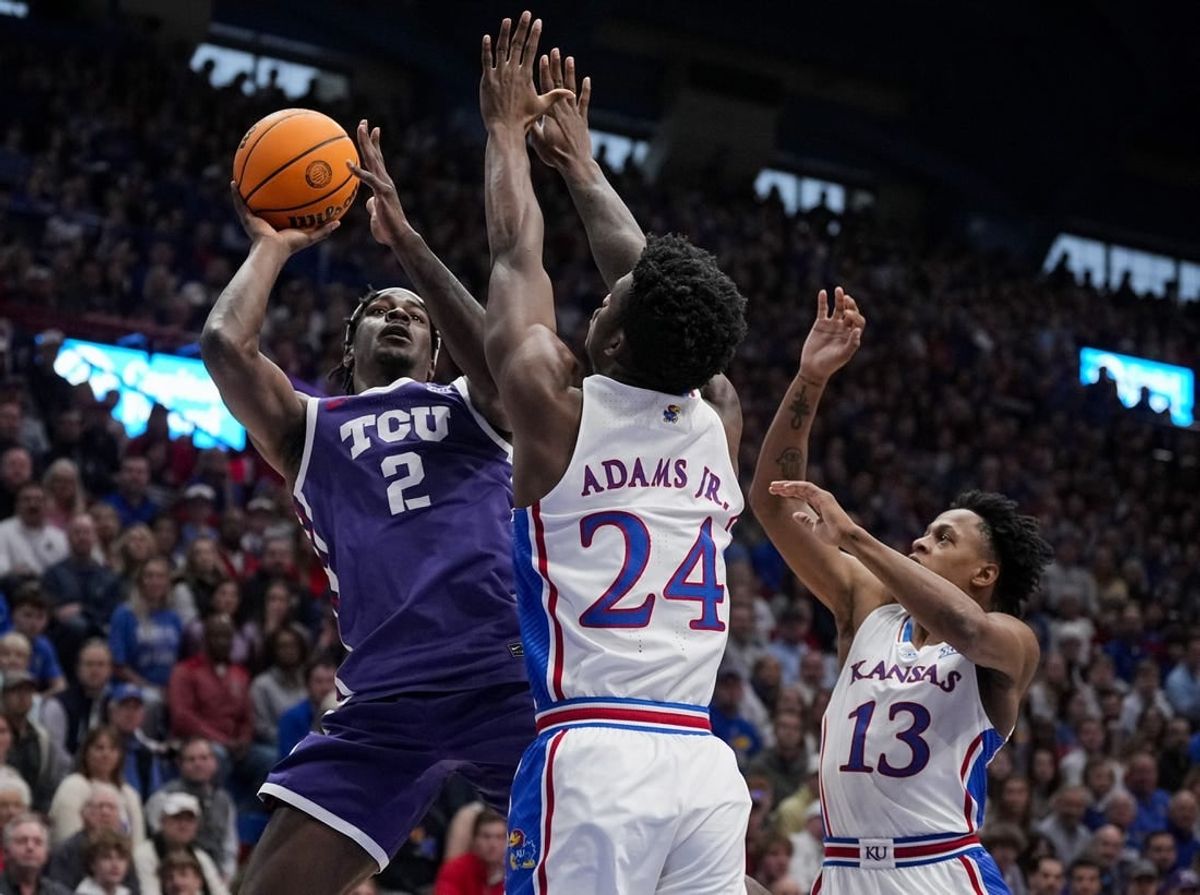 Jan 6, 2024; Lawrence, Kansas, USA; TCU Horned Frogs forward Emanuel Miller (2) shoots against Kansas Jayhawks forward K.J. Adams Jr. (24) and guard Elmarko Jackson (13) during the first half at Allen Fieldhouse.