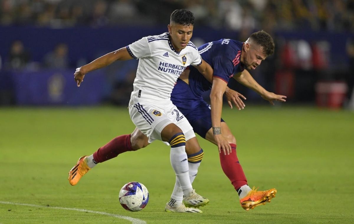 Aug 26, 2023; Carson, California, USA;  Los Angeles Galaxy midfielder Memo Rodriguez (20) and Chicago Fire midfielder Gaston Gimenez (30) battle for the ball in the first half at Dignity Health Sports Park.