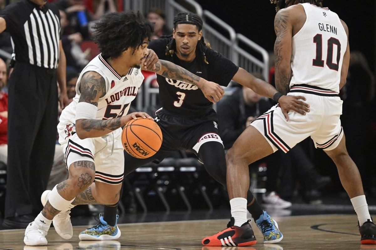Nov 26, 2023; Louisville, Kentucky, USA; Louisville Cardinals guard Skyy Clark (55) dribbles against New Mexico State Aggies guard Christian Cook (3) during the first half at KFC Yum! Center.