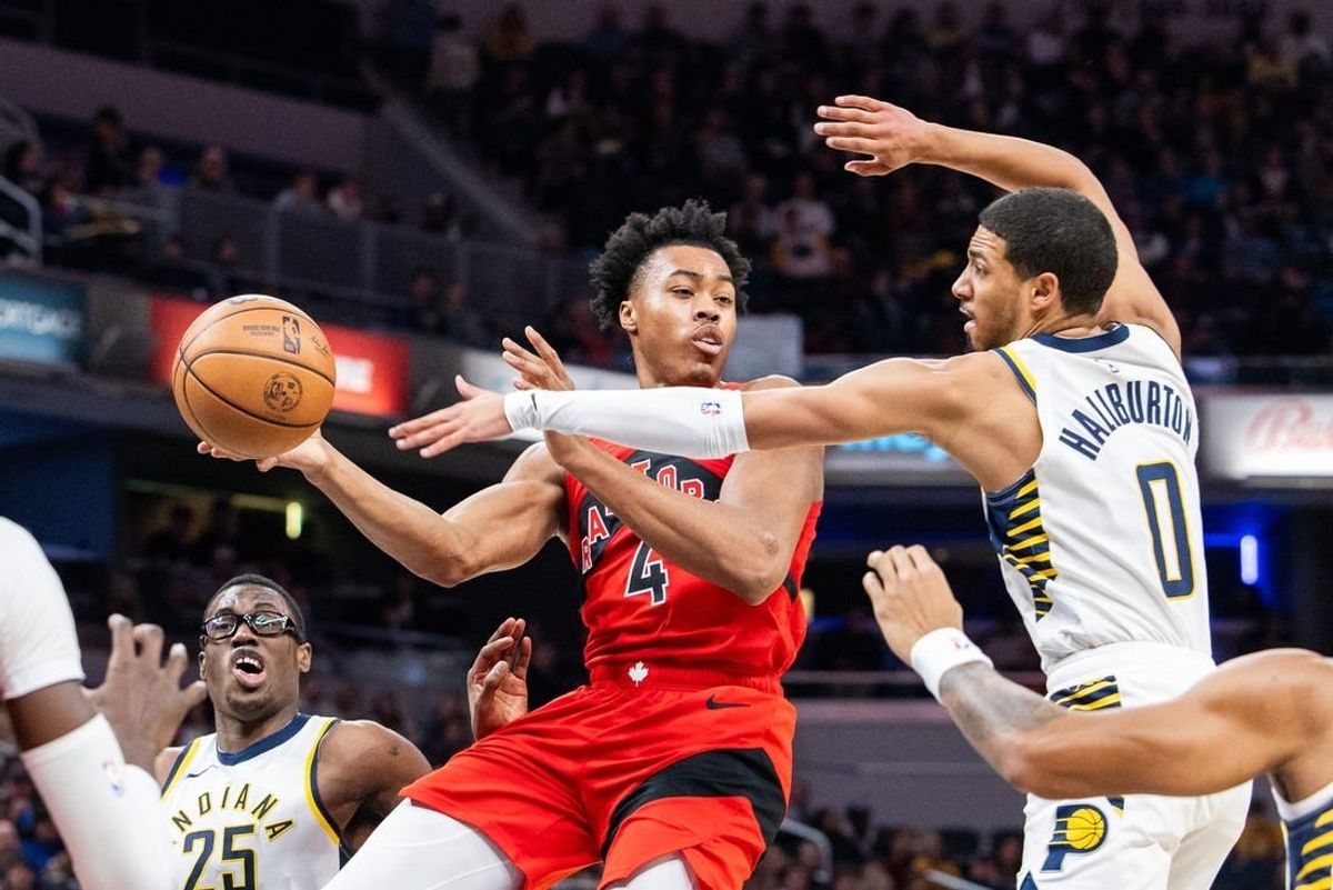 Nov 22, 2023; Indianapolis, Indiana, USA; Toronto Raptors forward Scottie Barnes (4) passes the ball while Indiana Pacers guard Tyrese Haliburton (0) defends in the first half at Gainbridge Fieldhouse.