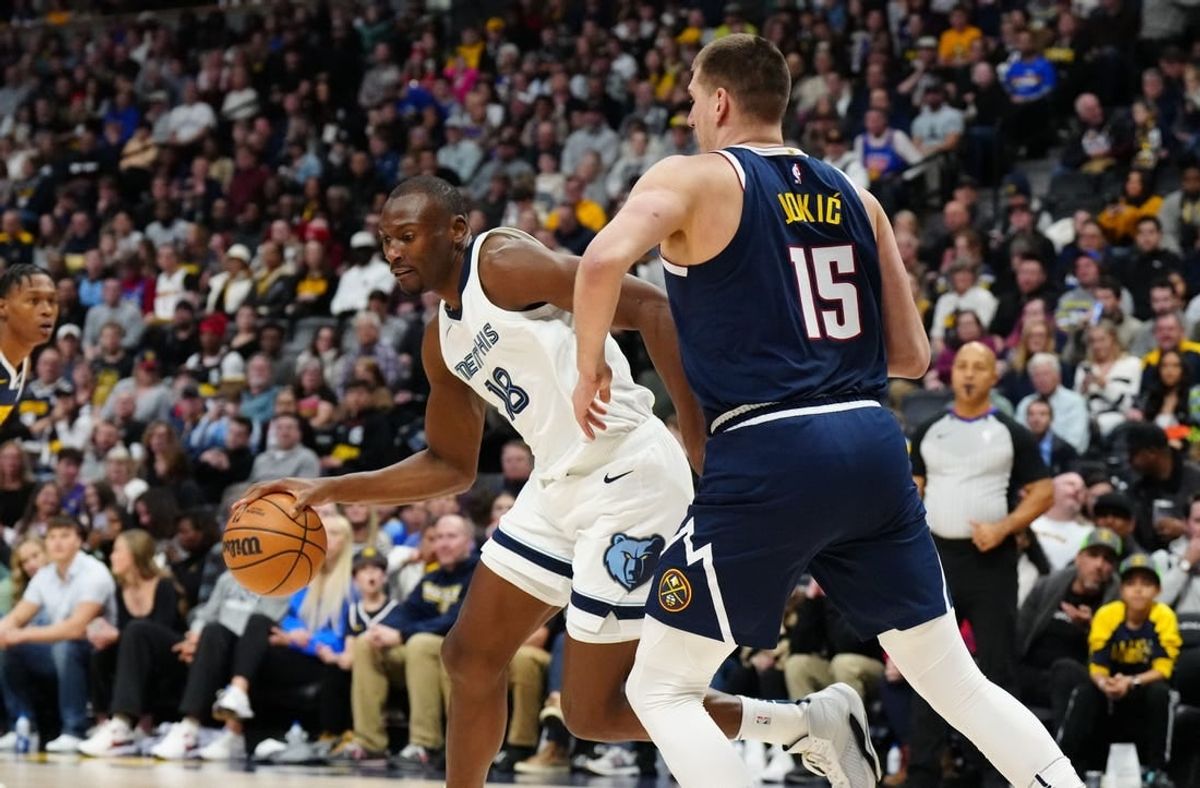 Dec 28, 2023; Denver, Colorado, USA; Memphis Grizzlies center Bismack Biyombo (18) drives at Denver Nuggets center Nikola Jokic (15) in the first quarter at Ball Arena.