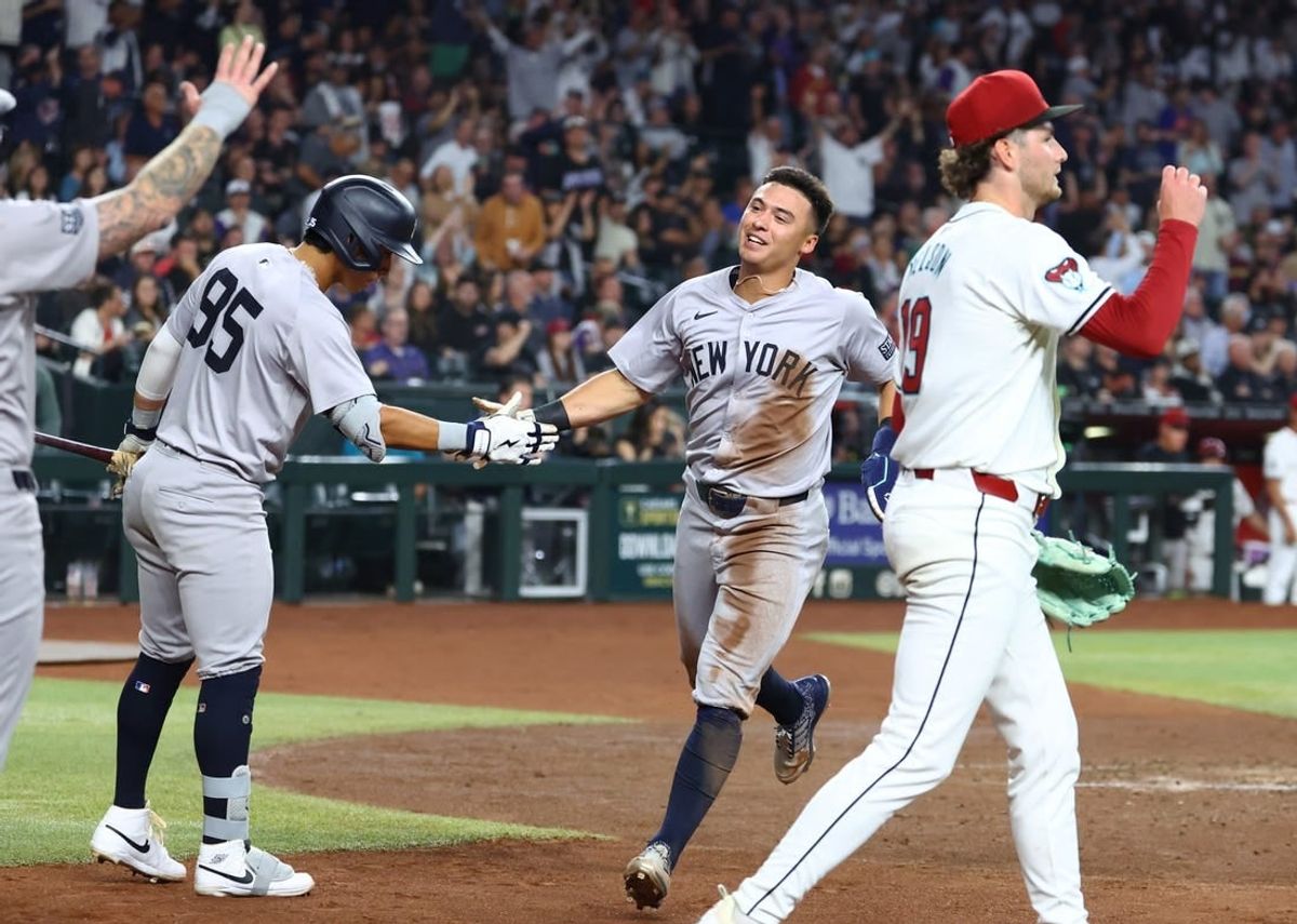 Apr 1, 2024; Phoenix, Arizona, USA; New York Yankees shortstop Anthony Volpe (center) celebrates with teammates after scoring against the Arizona Diamondbacks in the third inning at Chase Field.