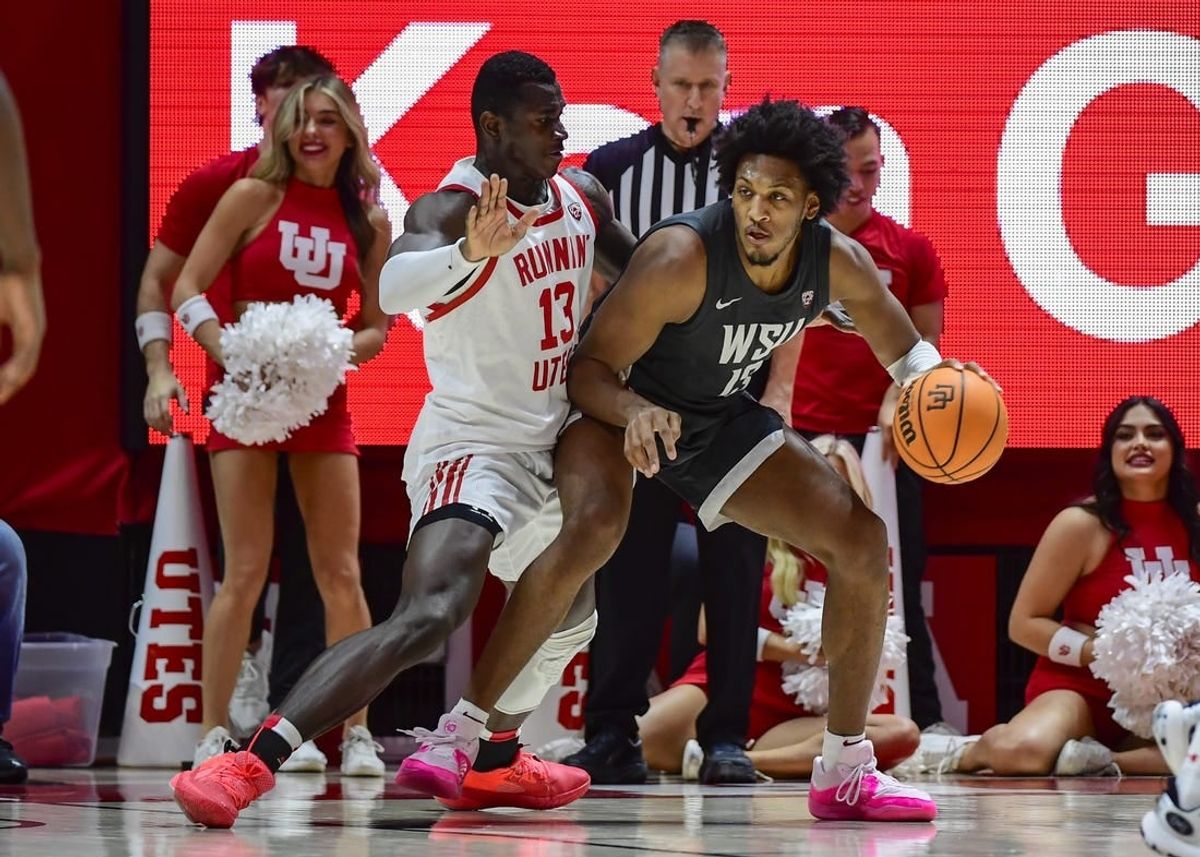 Dec 29, 2023; Salt Lake City, Utah, USA; Washington State Cougars forward Isaac Jones (13) dribbles around Utah Utes center Keba Keita (13) during the second half at the Jon M. Huntsman Center.