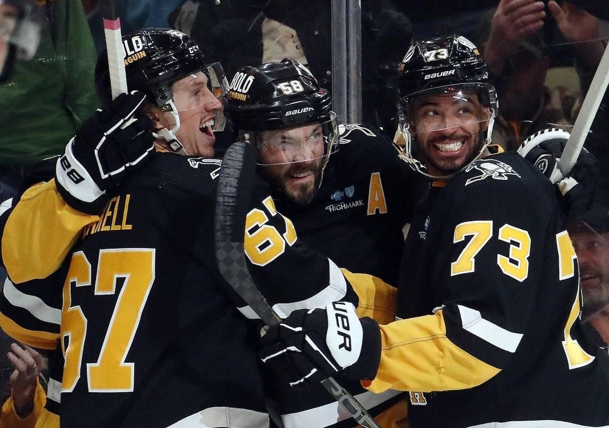 Apr 11, 2024; Pittsburgh, Pennsylvania, USA; Pittsburgh Penguins right wing Rickard Rakell (67) and defenseman Pierre-Olivier Joseph (73) congratulate defenseman Kris Letang (middle) on his goal against the Detroit Red Wings during the first period at PPG Paints Arena.