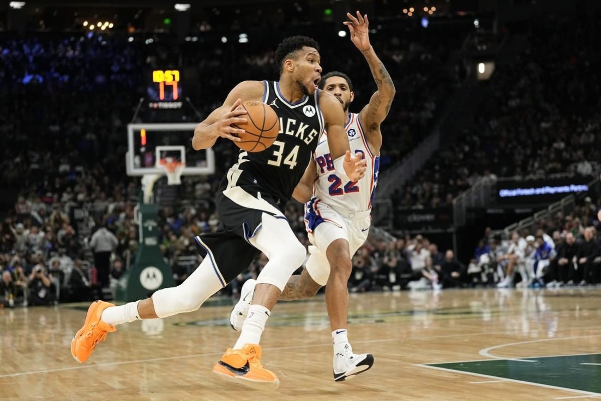 Mar 14, 2024; Milwaukee, Wisconsin, USA;  Milwaukee Bucks forward Giannis Antetokounmpo (34) drives for the basket in front of Philadelphia 76ers guard Cameron Payne (22) during the second quarter at Fiserv Forum.