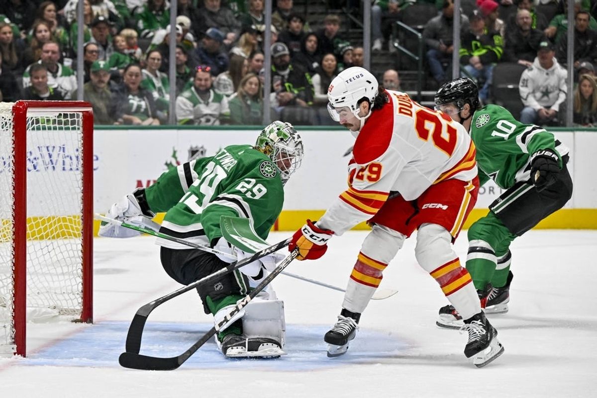 Nov 24, 2023; Dallas, Texas, USA; Dallas Stars goaltender Jake Oettinger (29) turns aside a shot by Calgary Flames center Dillon Dube (29) during the first period at the American Airlines Center.
