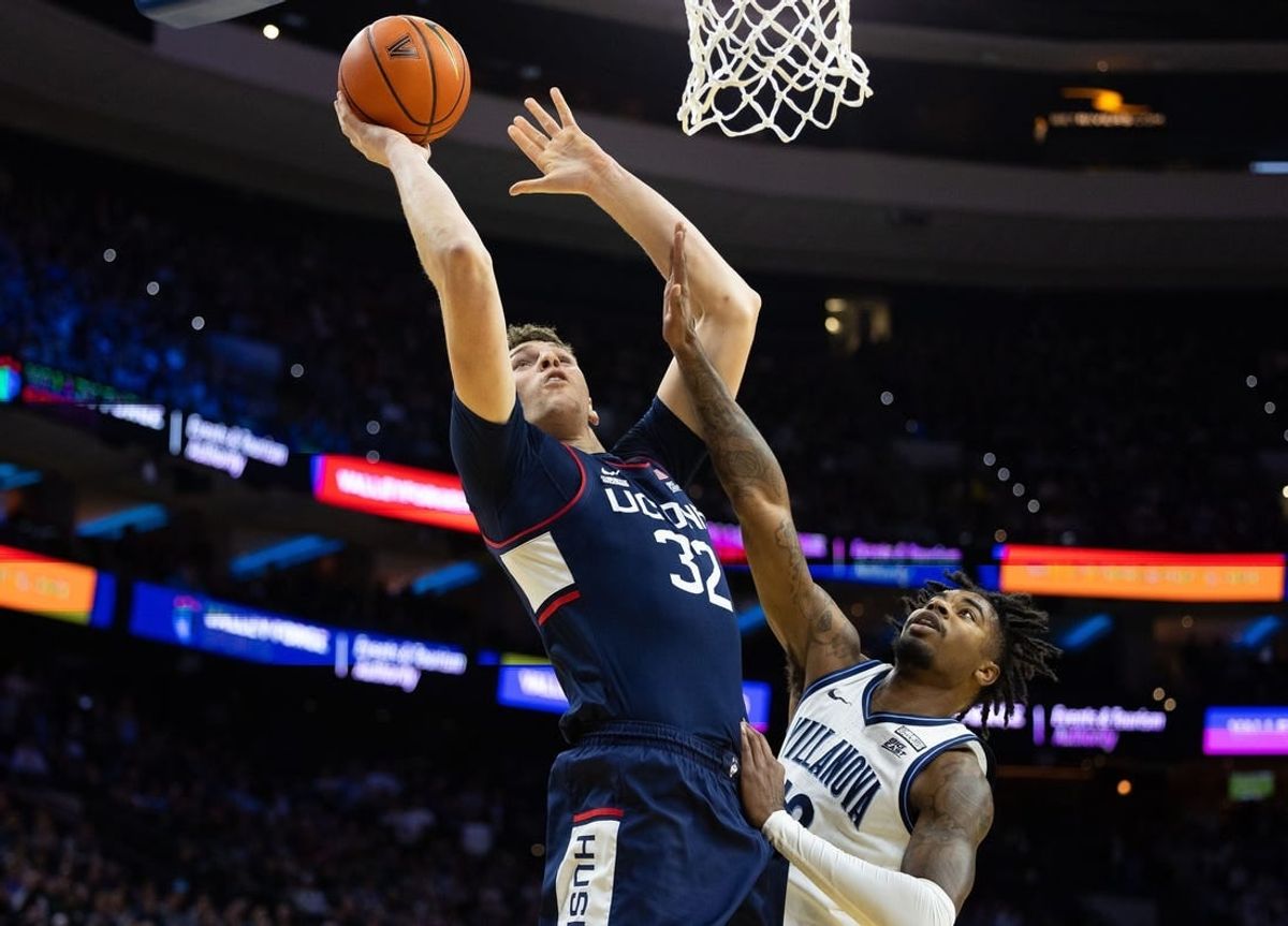Jan 20, 2024; Philadelphia, Pennsylvania, USA; Connecticut Huskies center Donovan Clingan (32) drives for a shot against Villanova Wildcats forward Jordann Dumont (10) during the first half at Wells Fargo Center.