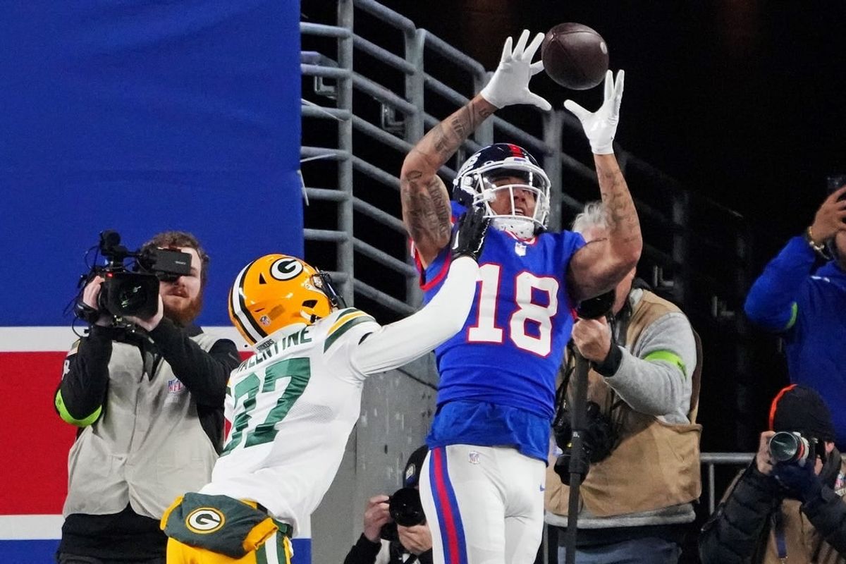 Dec 11, 2023; East Rutherford, New Jersey, USA; New York Giants wide receiver Isaiah Hodgins (18) catches a touchdown against Green Bay Packers cornerback Carrington Valentine (37) during the third quarter at MetLife Stadium.