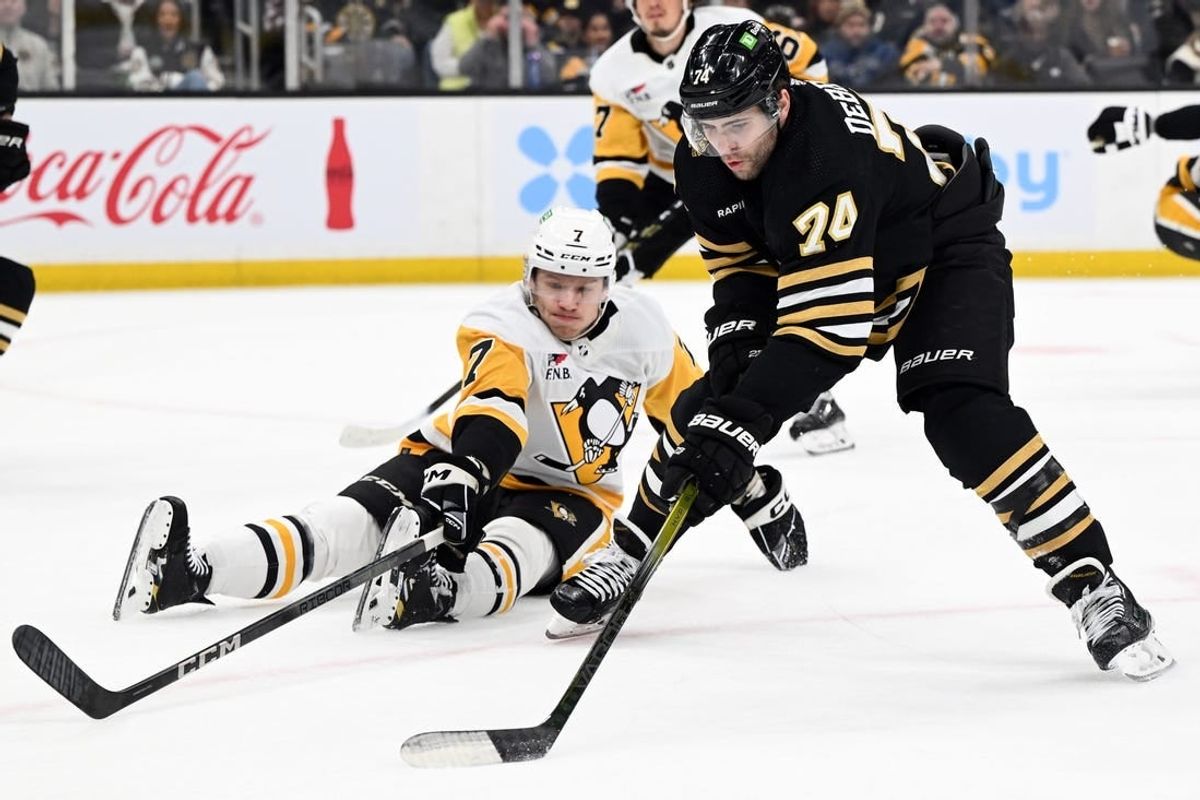 Mar 9, 2024; Boston, Massachusetts, USA; Boston Bruins left wing Jake DeBrusk (74) skates against Pittsburgh Penguins defenseman John Ludvig (7) during the first period at the TD Garden.