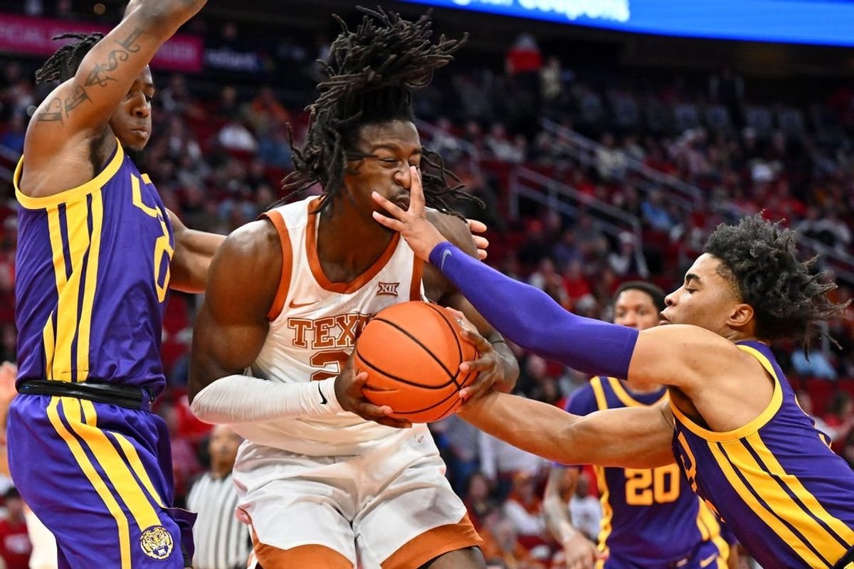 Dec 16, 2023; Houston, Texas, USA; Texas Longhorns forward Ze'Rik Onyema (21) battles for the ball against LSU Tigers guard Trae Hannibal (left) and guard Jalen Cook (right) during the first half at Toyota Center.