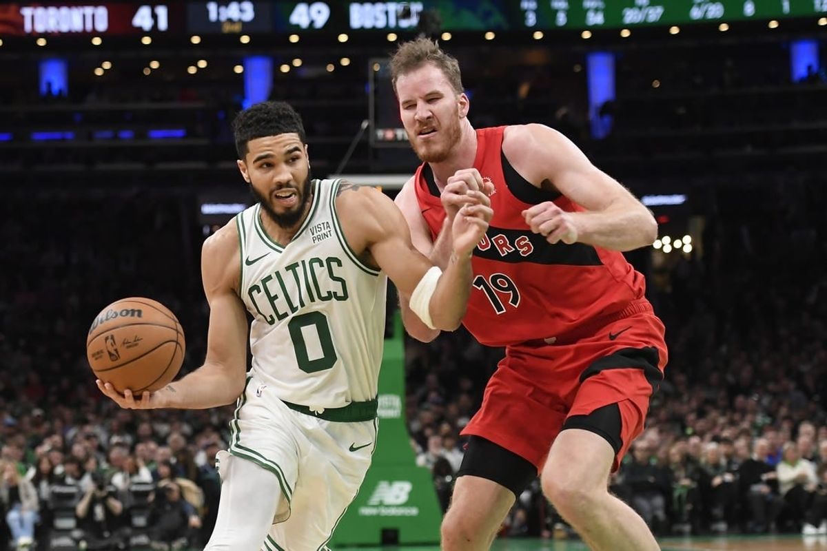 Nov 11, 2023; Boston, Massachusetts, USA;  Boston Celtics forward Jayson Tatum (0) drives to the basket past Toronto Raptors center Jakob Poeltl (19) during the first half at TD Garden.