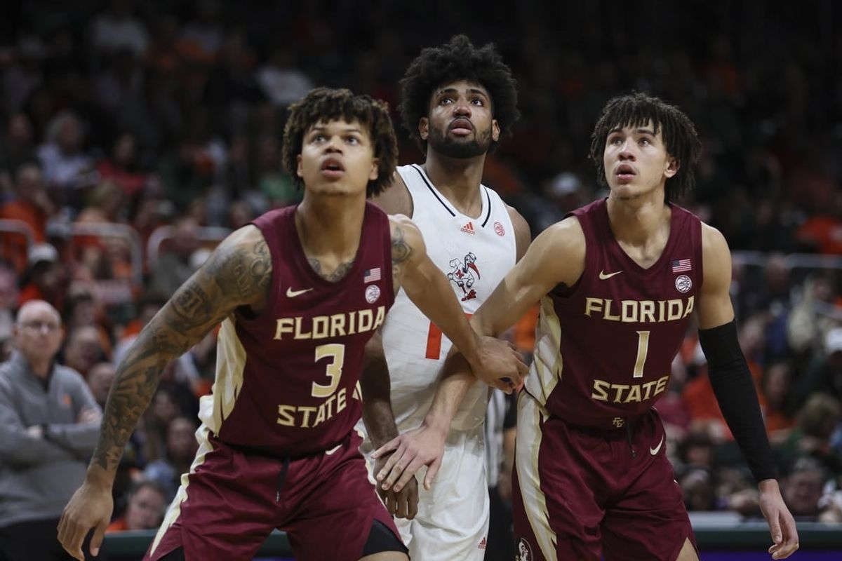 Jan 17, 2024; Coral Gables, Florida, USA; Miami Hurricanes forward Norchad Omier (15) looks on as Florida State Seminoles forward Cam Corhen (3) and guard Jalen Warley (1) defend during the second half at Watsco Center.