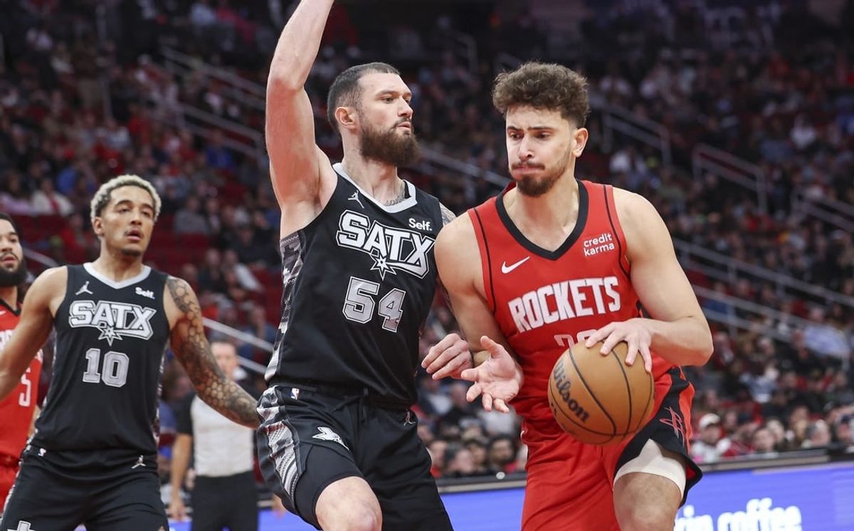 Dec 11, 2023; Houston, Texas, USA; Houston Rockets center Alperen Sengun (28) controls the ball as San Antonio Spurs forward Sandro Mamukelashvili (54) defends during the second quarter at Toyota Center.