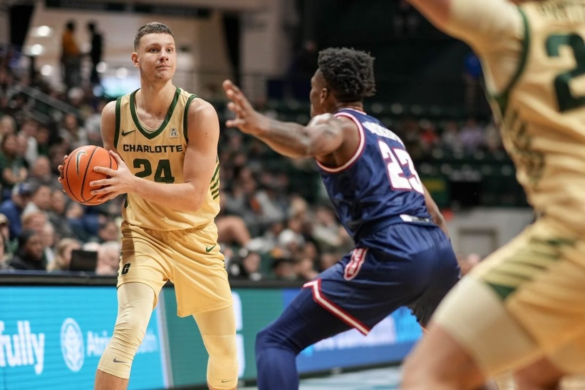 Jan 6, 2024; Charlotte, North Carolina, USA; Charlotte 49ers forward Igor Milicic Jr. (24) looks to pass around Florida Atlantic Owls guard Brandon Weatherspoon (23) during the first half at Dale F. Halton Arena.