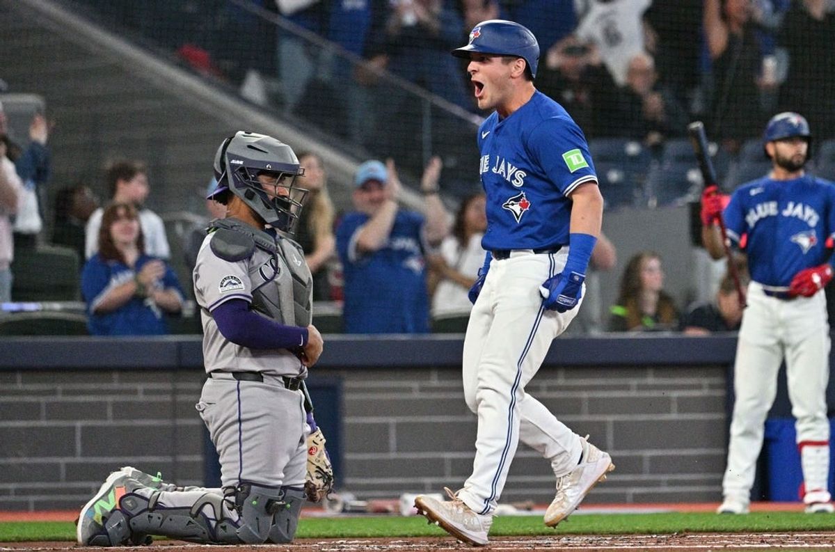 Apr 13, 2024; Toronto, Ontario, CAN;  Toronto Blue Jays center fielder Daulton Varsho (25) reacts beside Colorado Rockies catcher Elias Diaz (35) after hitting a grand slam home run in the first inning at Rogers Centre.