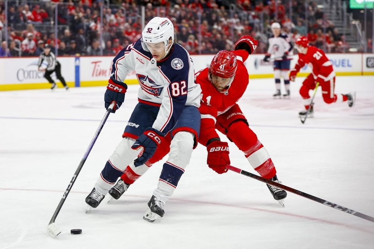 Mar 19, 2024; Detroit, Michigan, USA; Columbus Blue Jackets left wing Mikael Pyyhtia (82) handles the puck against Detroit Red Wings defenseman Shayne Gostisbehere (41) during the first period of the game against the Detroit Red Wings at Little Caesars Arena.