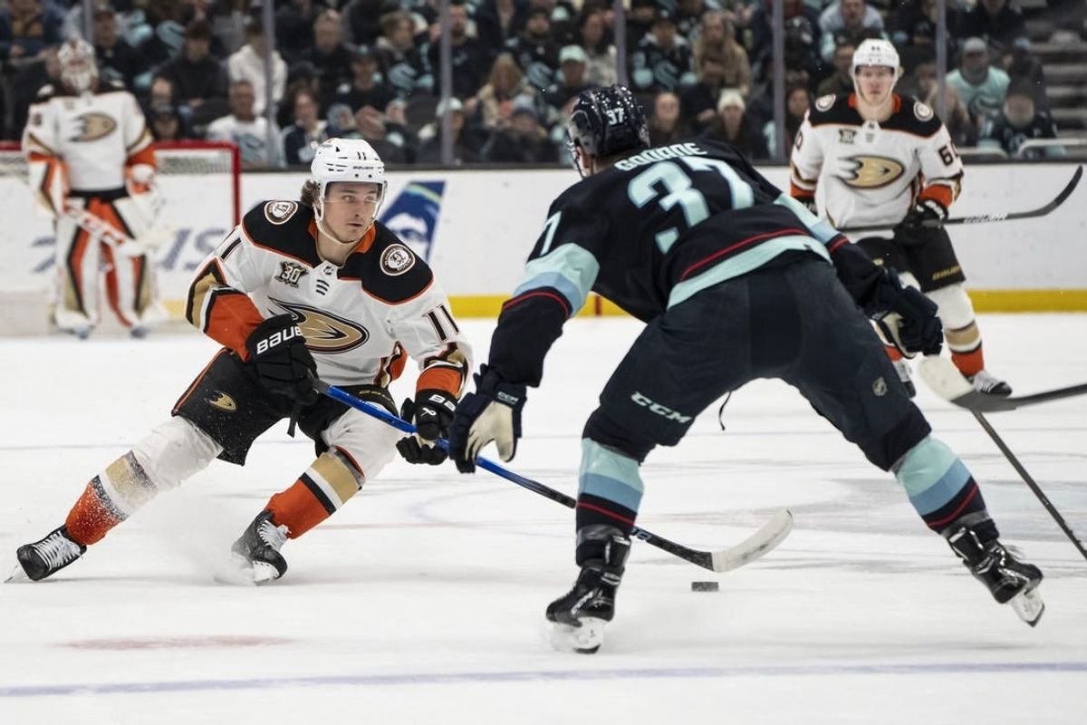 Mar 26, 2024; Seattle, Washington, USA; Anaheim Ducks forward Trevor Zegras (11) skates against Seattle Kraken forward Yanni Gourde (37) during the first period at Climate Pledge Arena.