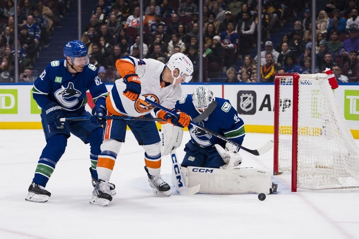 Nov 15, 2023; Vancouver, British Columbia, CAN; Vancouver Canucks goalie Thatcher Demko (35) watches the rebound as defenseman Ian Cole (82) battles with New York Islanders forward Bo Horvat (14) in the first period at Rogers Arena.