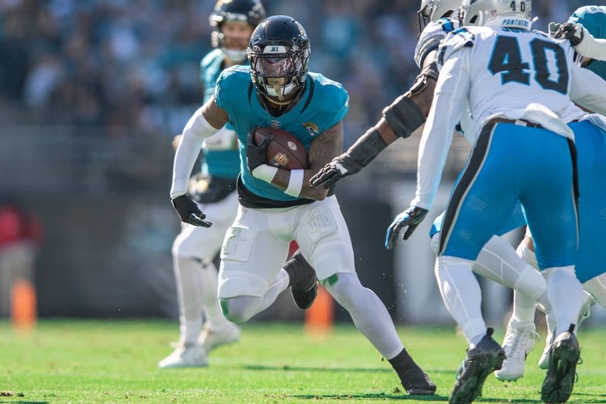 Dec 31, 2023; Jacksonville, Florida, USA; Jacksonville Jaguars running back Travis Etienne Jr. (1) runs the ball against the Carolina Panthers in the first quarter at EverBank Stadium.