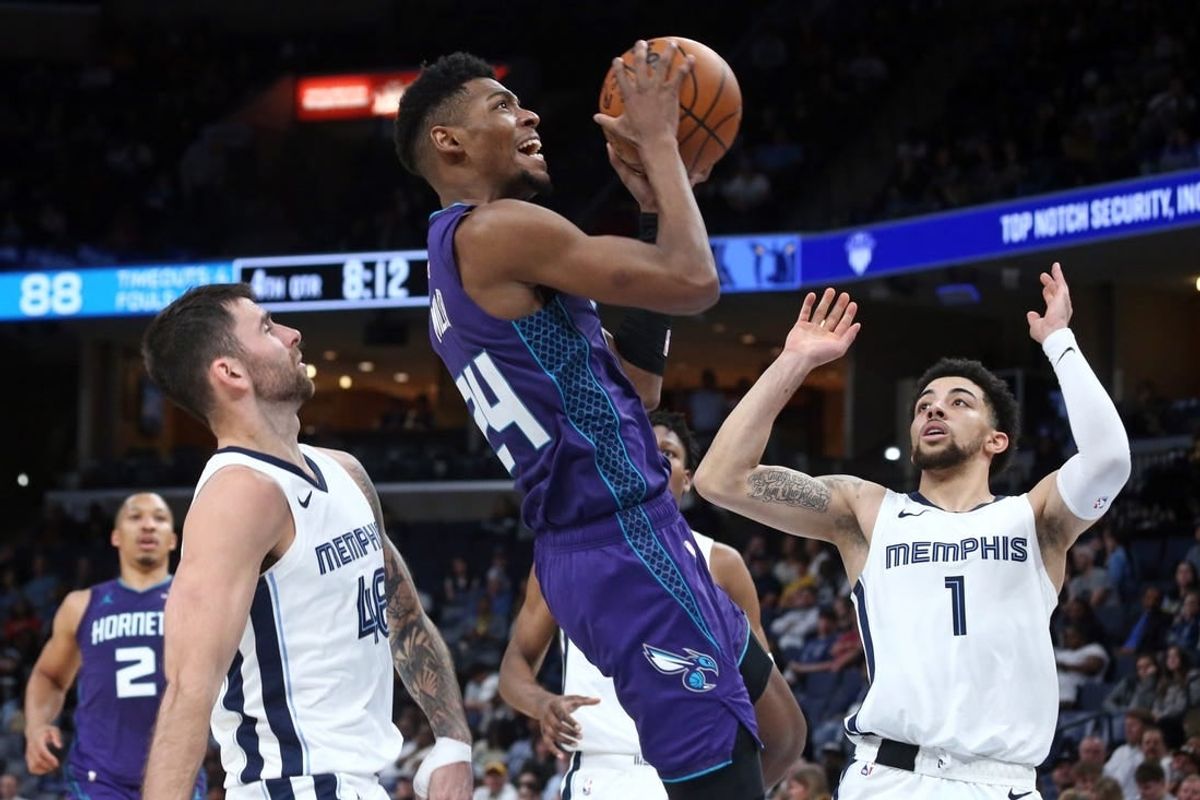 Mar 12, 2024; Memphis, Tennessee, USA; Charlotte Hornets forward Brandon Miller (24) drives to the basket between Memphis Grizzlies guard John Konchar (46) and guard Scotty Pippen Jr. (1)  during the second half at FedExForum.