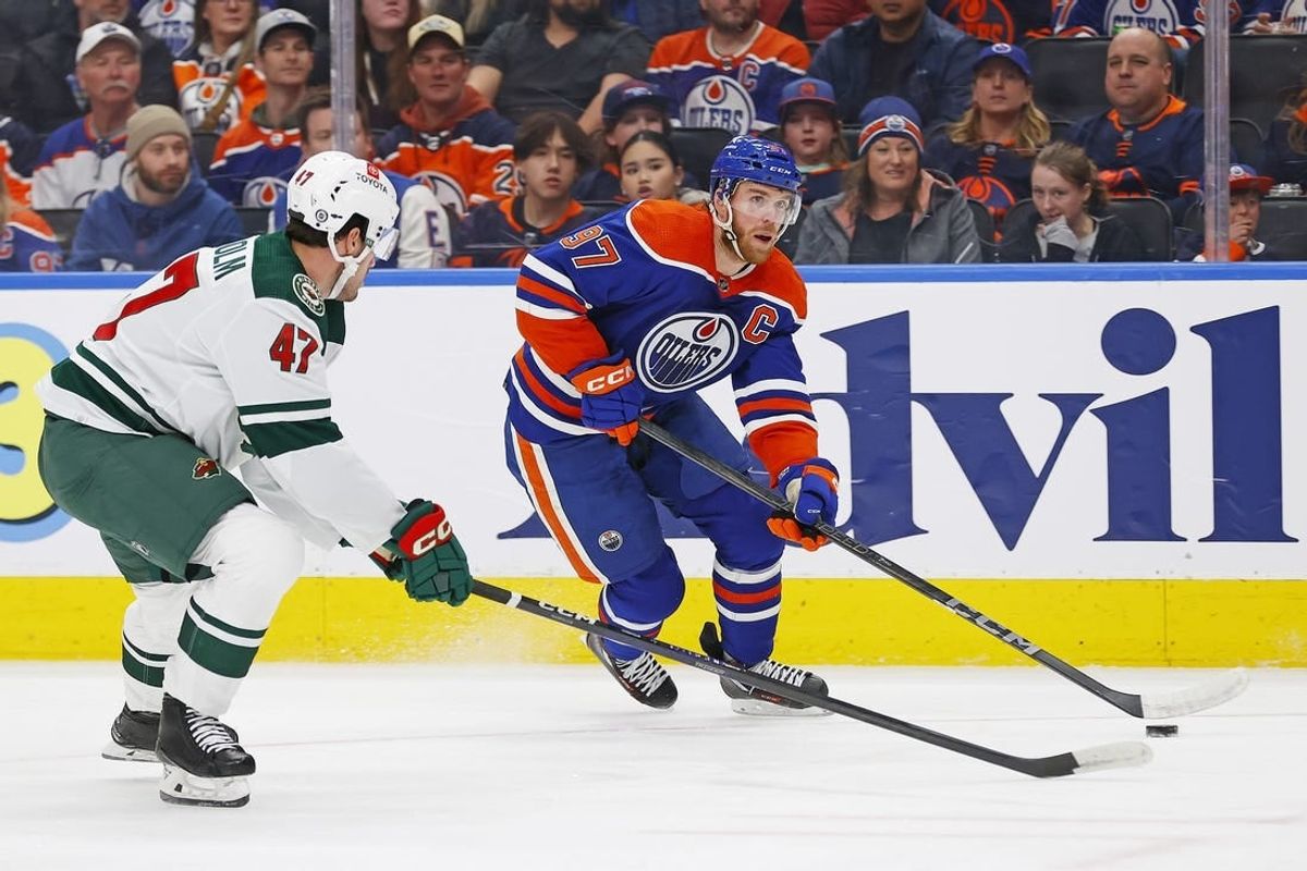 Feb 23, 2024; Edmonton, Alberta, CAN; Edmonton Oilers forward Connor McDavid (97) carries the puck around Minnesota Wild defensemen Declan Chisholm (47) during the first period at Rogers Place.