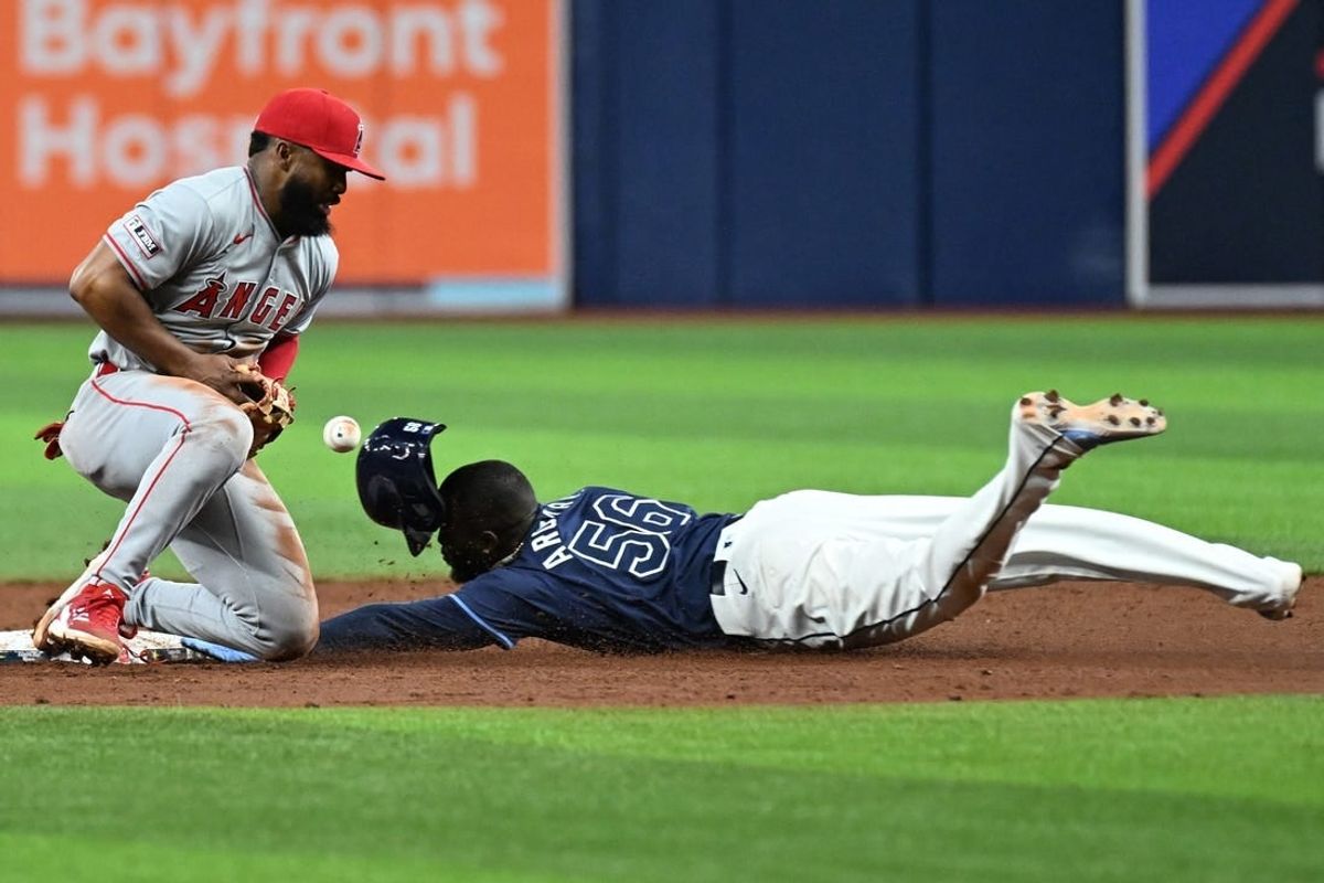 Apr 17, 2024; St. Petersburg, Florida, USA; Tampa Bay Rays left fielder Randy Arozarena (56) slides into second base as Los Angeles Angels second baseman Luis Rengifo (2) attempts to catch the ball the sixth inning at Tropicana Field.