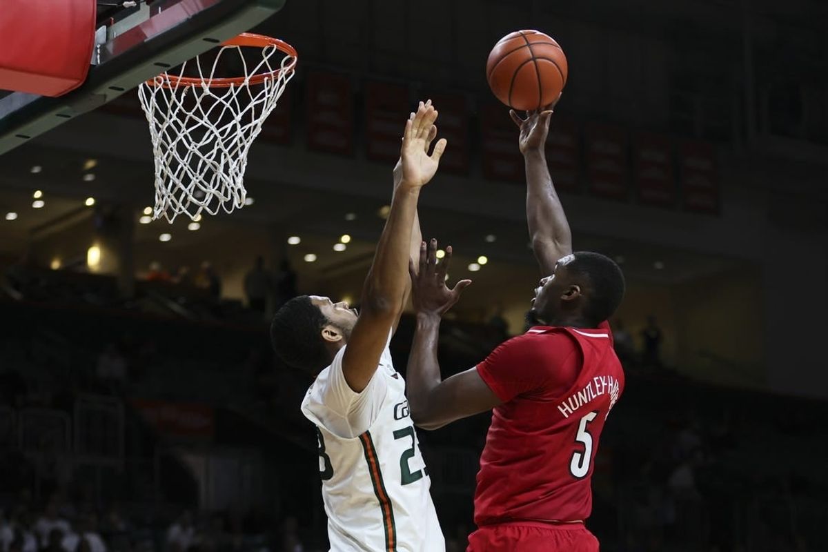 Jan 10, 2024; Coral Gables, Florida, USA; Louisville Cardinals forward Brandon Huntley-Hatfield (5) shoots the basketball over Miami Hurricanes forward AJ Casey (23) during the first half at Watsco Center.