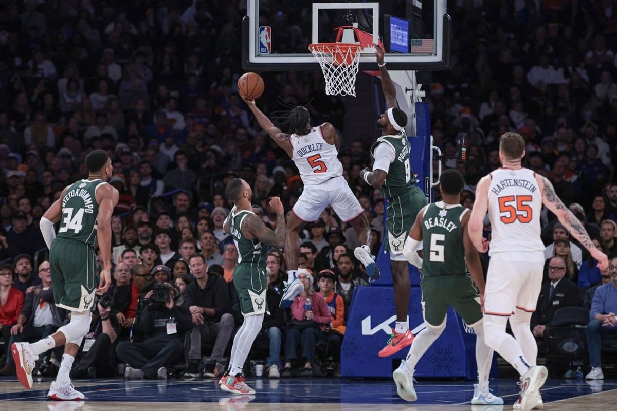 Dec 25, 2023; New York, New York, USA; New York Knicks guard Immanuel Quickley (5) drives to the basket as Milwaukee Bucks forward Bobby Portis (9) and guard Damian Lillard (0) defend during the second half at Madison Square Garden.