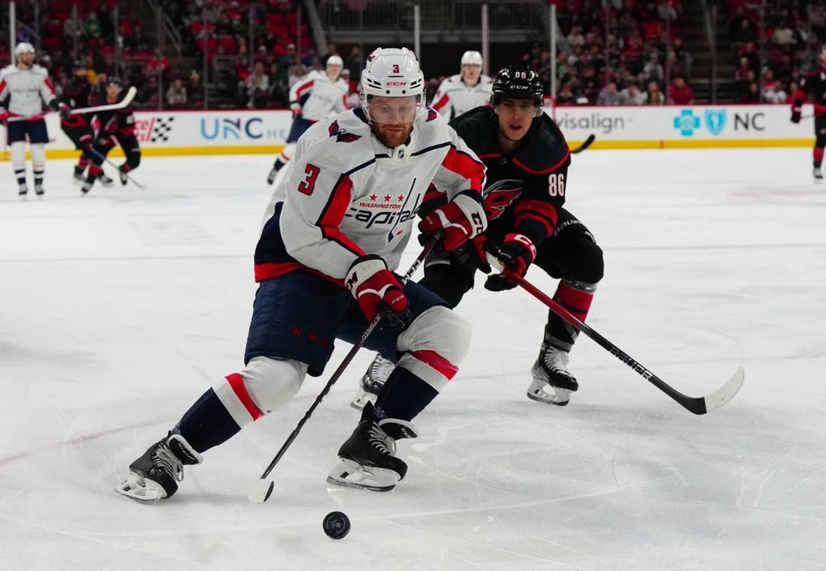 Dec 17, 2023; Raleigh, North Carolina, USA;  Washington Capitals defenseman Nick Jensen (3) skates with the puck past Carolina Hurricanes left wing Teuvo Teravainen (86) during the first period at PNC Arena.