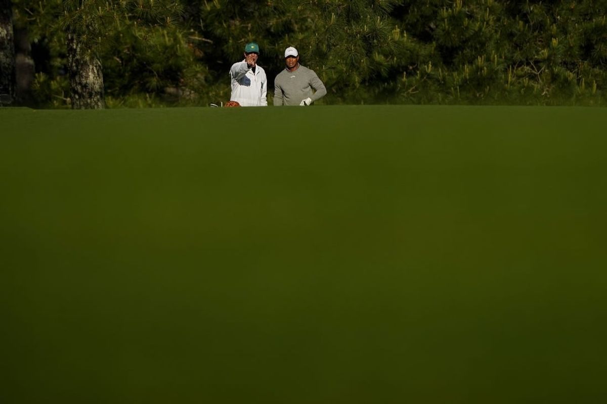 Apr 12, 2024; Augusta, Georgia, USA; Tiger Woods and his caddie, Lance Bennett, look down the no. 17 fairway during the completion of the first round of the Masters Tournament.