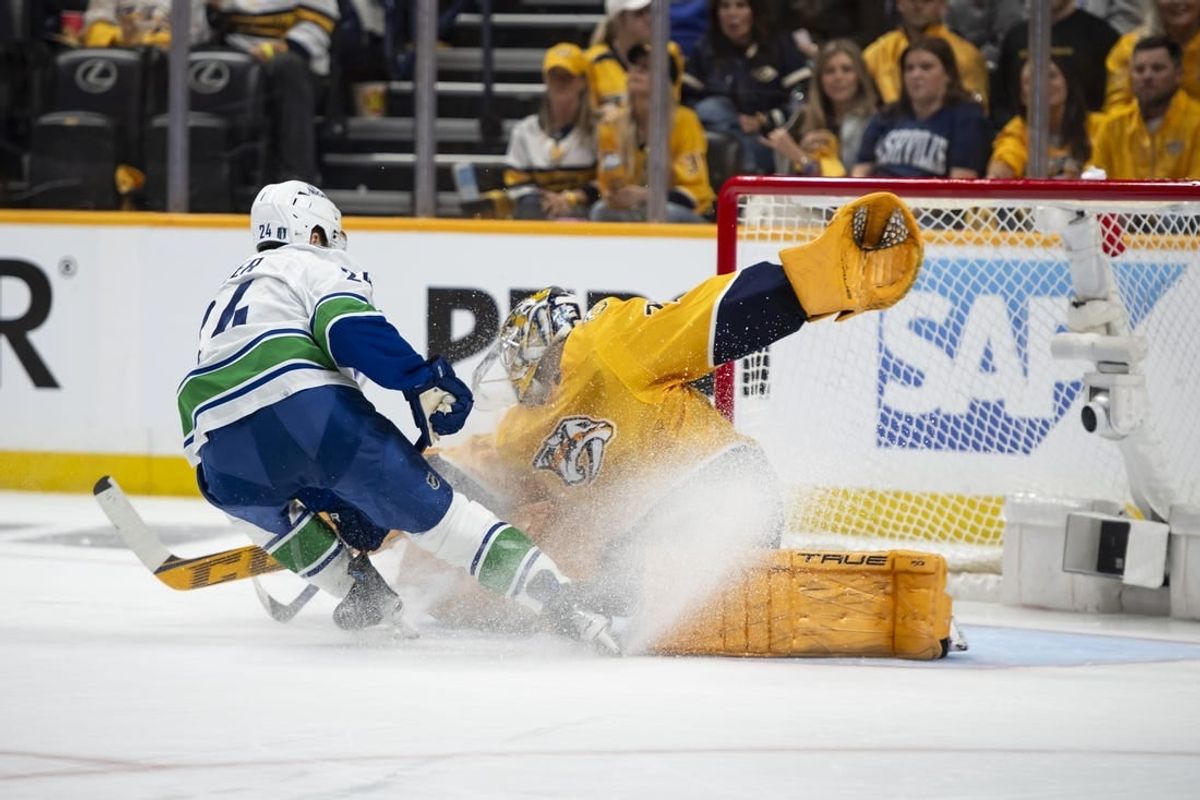 May 3, 2024; Nashville, Tennessee, USA; Nashville Predators goaltender Juuse Saros (74) blocks the shot of Vancouver Canucks center Pius Suter (24) during the second period in game six of the first round of the 2024 Stanley Cup Playoffs at Bridgestone Arena.