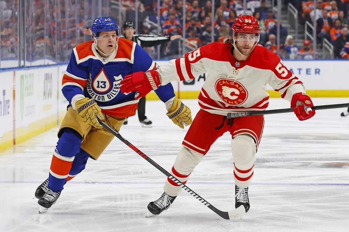 Feb 24, 2024; Edmonton, Alberta, CAN; Calgary Flames defensemen Noah Hanifin (55) and Edmonton Oilers forward Mattias Janmark (13) chase a loose puck during the first period at Rogers Place.