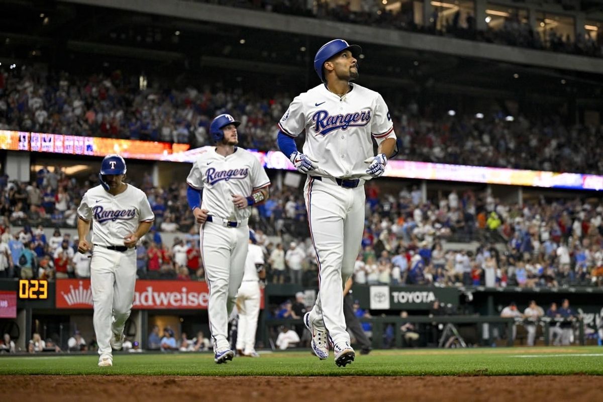 Apr 5, 2024; Arlington, Texas, USA; Texas Rangers second base Marcus Semien (2) and catcher Jonah Heim (28) and third baseman Josh Smith (8) come off the field after Semien hits a three run home run against the Houston Astros during the sixth inning at Globe Life Field.