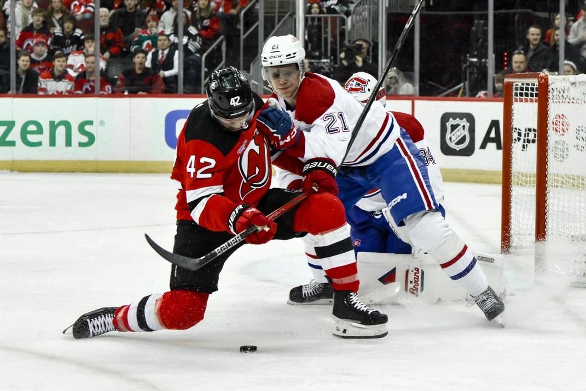 Feb 24, 2024; Newark, New Jersey, USA; New Jersey Devils center Curtis Lazar (42) skates with the puck while being defended by Montreal Canadiens defenseman Kaiden Guhle (21) during the second period at Prudential Center.