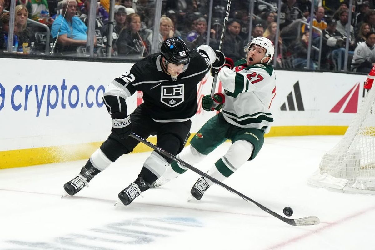 Apr 15, 2024; Los Angeles, California, USA; LA Kings left wing Kevin Fiala (22) and Minnesota Wild center Jacob Lucchini (27) battle for the puck in the third period at Crypto.com Arena.
