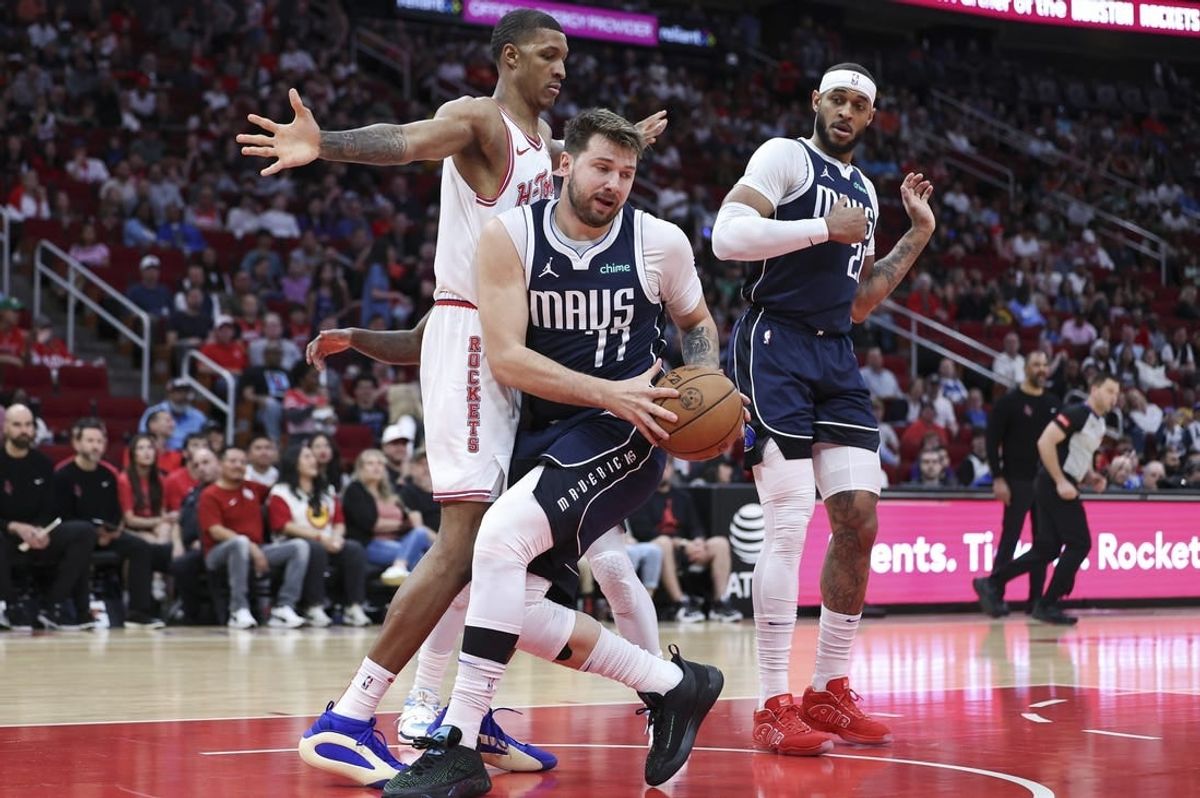 Mar 31, 2024; Houston, Texas, USA; Dallas Mavericks guard Luka Doncic (77) grabs a rebound away from Houston Rockets forward Jabari Smith Jr. (10) during the first quarter at Toyota Center.