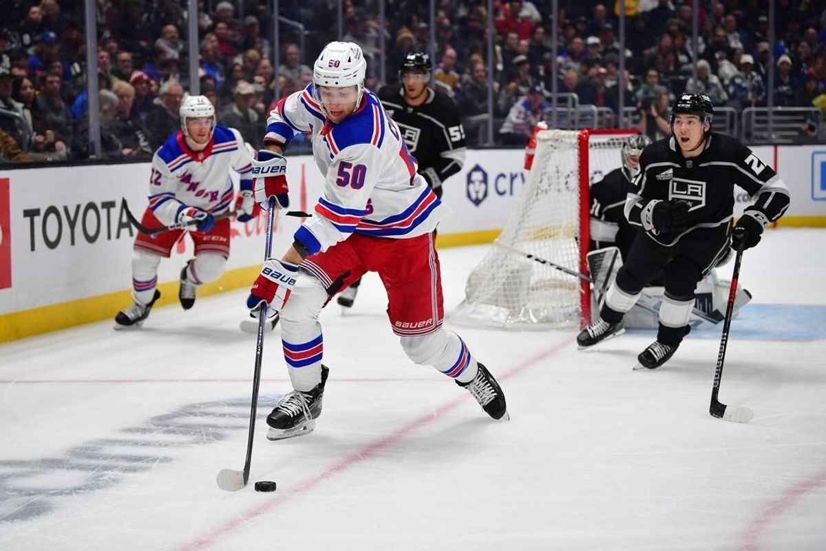 Jan 20, 2024; Los Angeles, California, USA; New York Rangers left wing Will Cuylle (50) moves the puck ahead of Los Angeles Kings defenseman Jordan Spence (21) durng the first period at Crypto.com Arena.