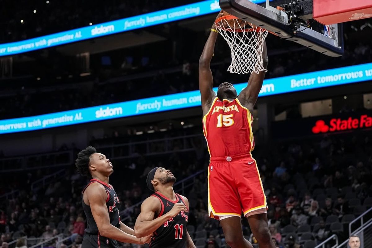 Jan 28, 2024; Atlanta, Georgia, USA; Atlanta Hawks center Clint Capela (15) dunks behind Toronto Raptors forwards Scottie Barnes (4) and Bruce Brown (11) during the first half at State Farm Arena.